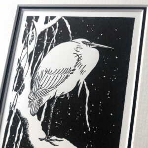 handmade monochrome woodblock print of an egret sitting on a snow-covered branch, after Koson