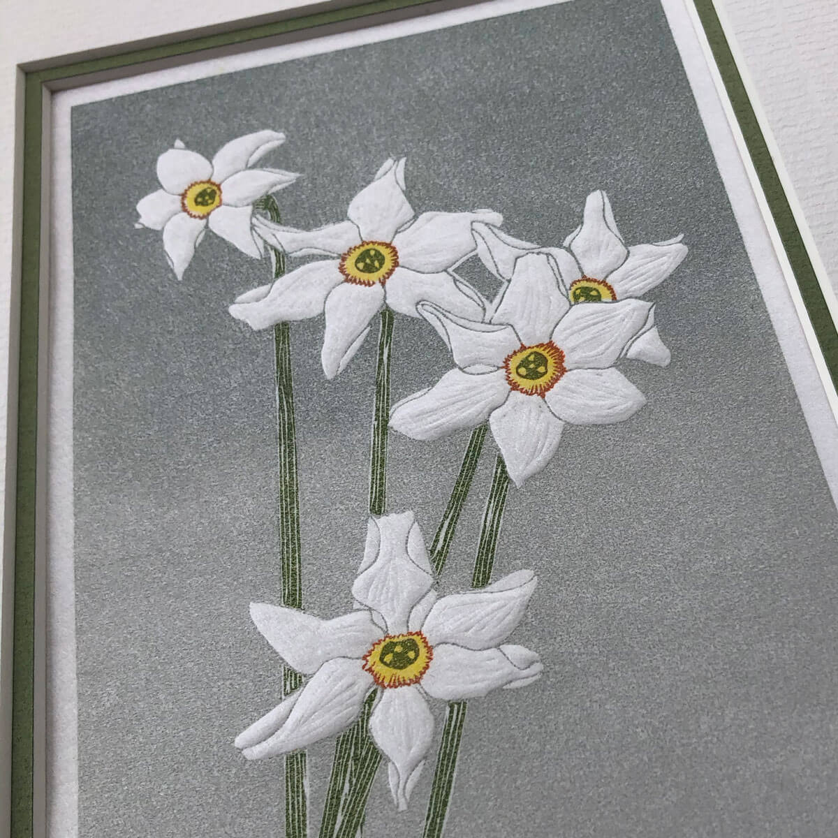 handmade linocut print of white narcissus poeticus flowers against graded grey background
